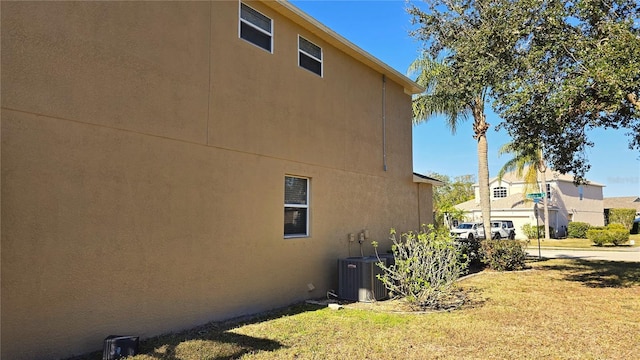 view of side of home featuring a yard and central air condition unit