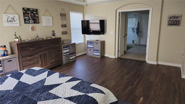 bedroom with dark wood-type flooring and ensuite bath