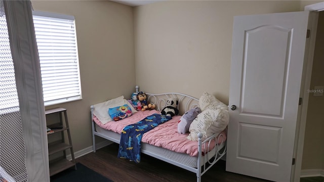 bedroom featuring multiple windows and dark wood-type flooring