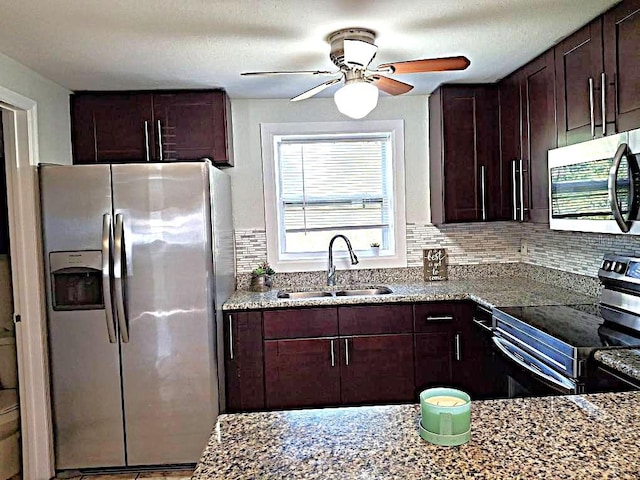 kitchen with light stone counters, sink, backsplash, and appliances with stainless steel finishes