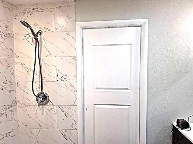 interior details featuring a tile shower