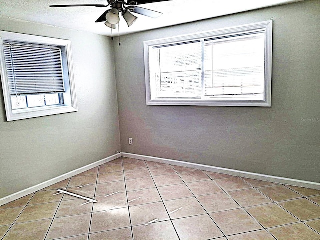 empty room with light tile patterned floors and ceiling fan