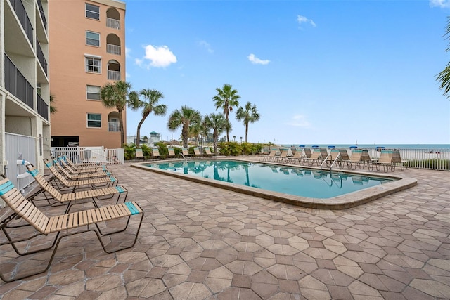 view of pool with a water view and a patio area