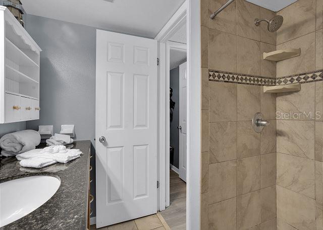 bathroom featuring a tile shower and vanity