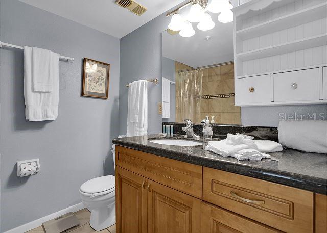 bathroom with vanity, tile patterned floors, toilet, and walk in shower