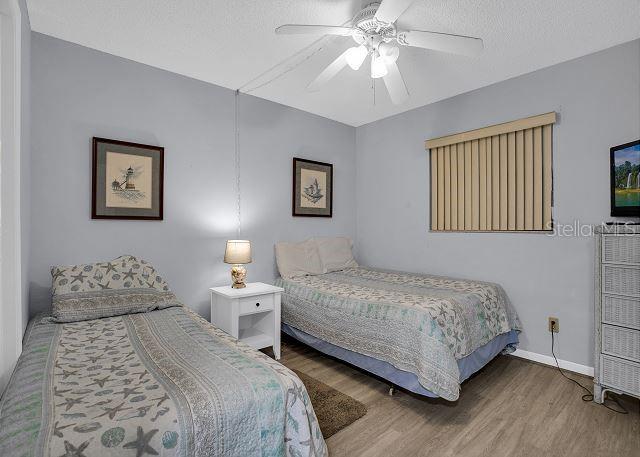 bedroom with ceiling fan, hardwood / wood-style floors, and a textured ceiling