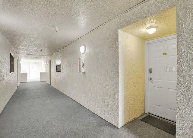 hall featuring a textured ceiling