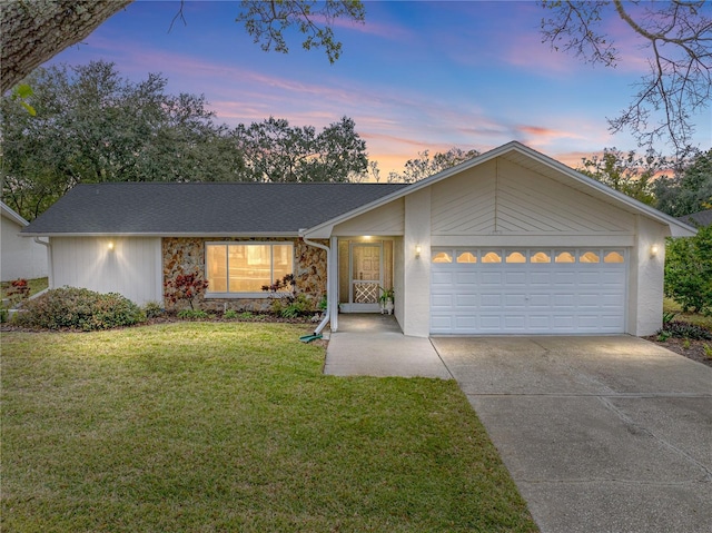 ranch-style home featuring a garage and a yard