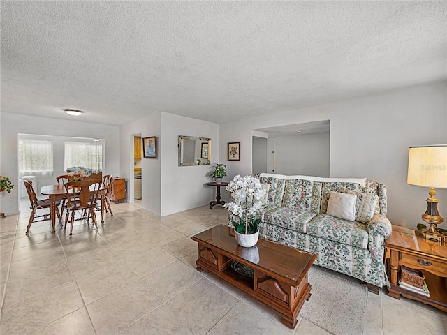 living room featuring light tile patterned flooring and a textured ceiling