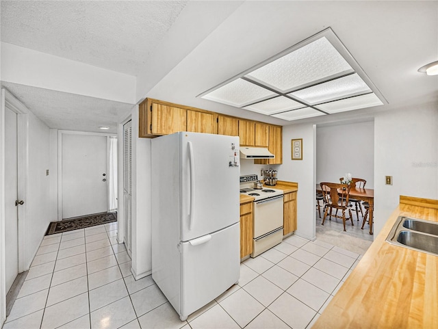 kitchen featuring light tile patterned flooring, white appliances, sink, and a textured ceiling