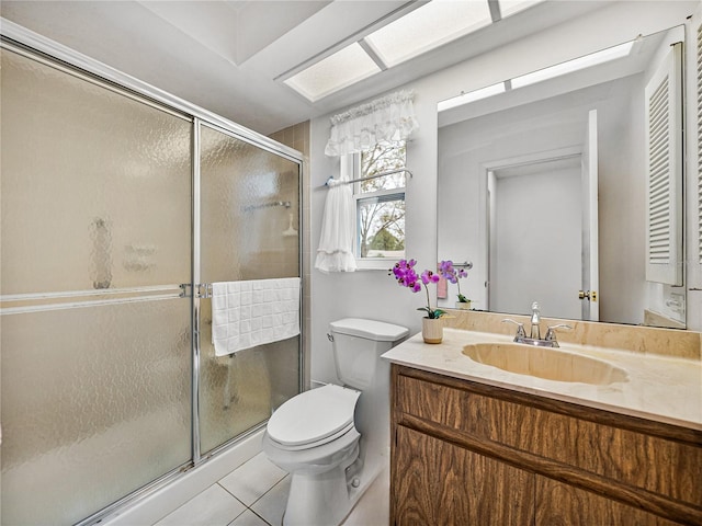 bathroom with vanity, a shower with shower door, tile patterned floors, and toilet