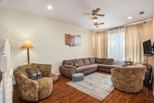 living room featuring hardwood / wood-style floors, a textured ceiling, and ceiling fan