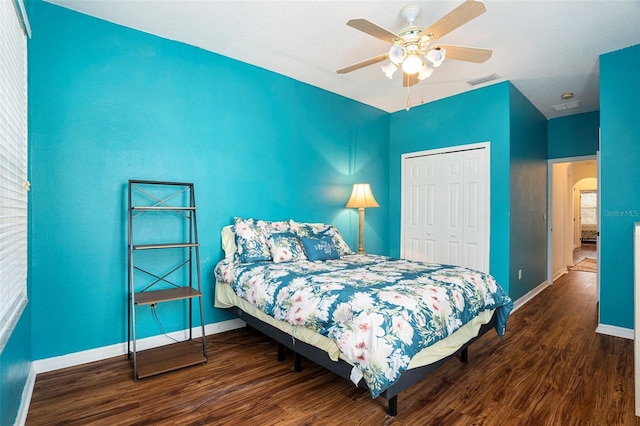 bedroom with ceiling fan, dark hardwood / wood-style flooring, and a closet