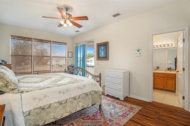 bedroom with hardwood / wood-style floors, sink, access to outside, ceiling fan, and ensuite bath