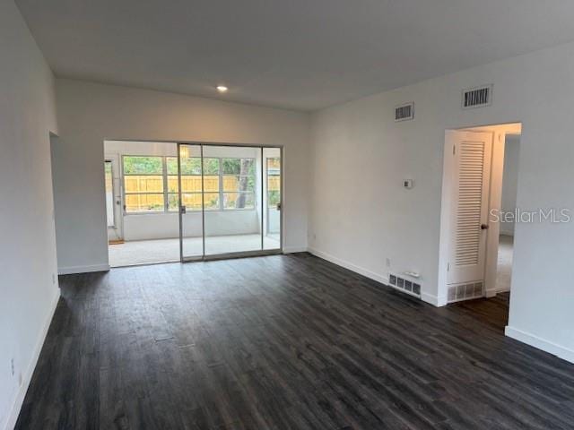 unfurnished room with dark wood-type flooring