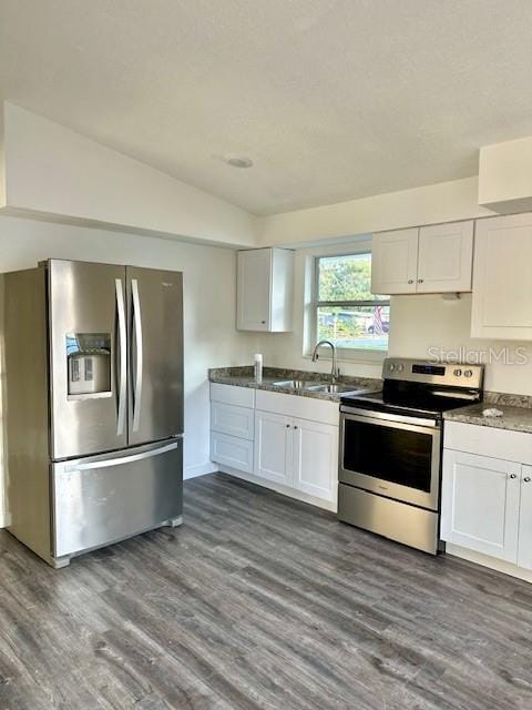 kitchen featuring dark wood-type flooring, sink, white cabinetry, vaulted ceiling, and appliances with stainless steel finishes