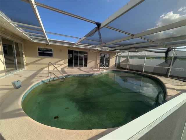 view of swimming pool with a patio area and glass enclosure