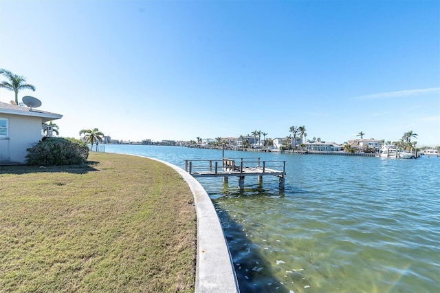 view of dock with a lawn and a water view