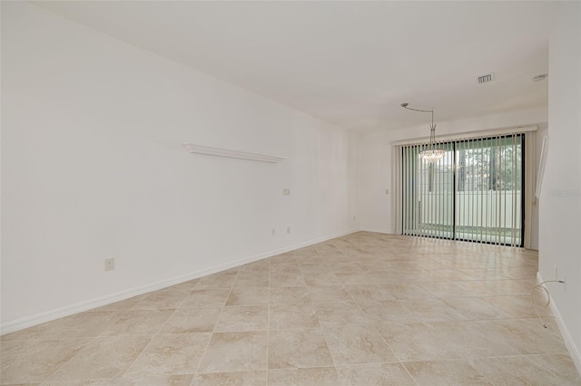 unfurnished room with a chandelier