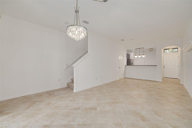 unfurnished living room featuring an inviting chandelier