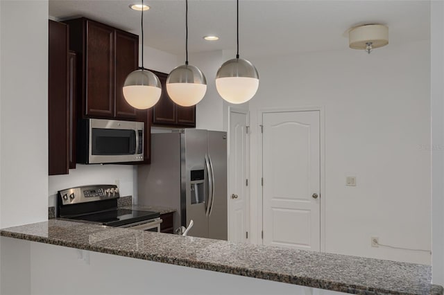 kitchen with kitchen peninsula, decorative light fixtures, stainless steel appliances, dark stone counters, and dark brown cabinetry