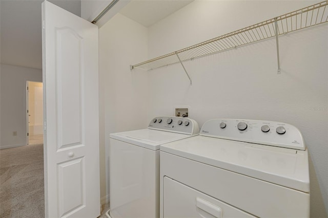 laundry room with washing machine and dryer and light colored carpet