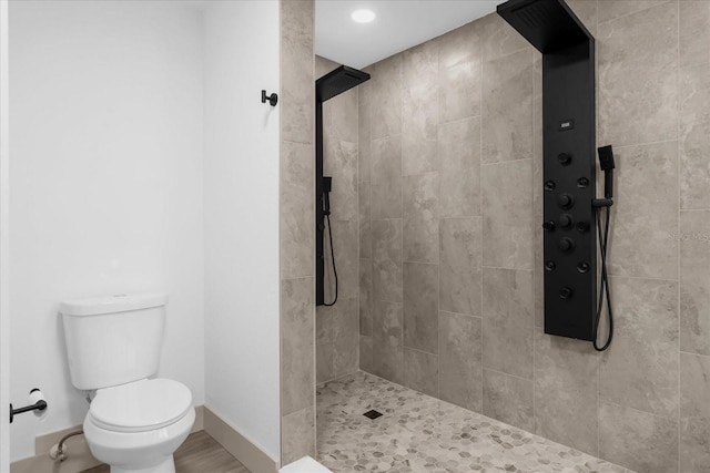 bathroom featuring toilet and a tile shower