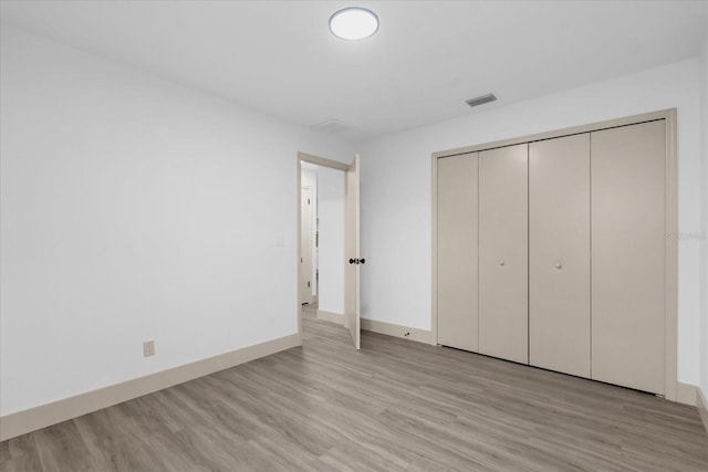 unfurnished bedroom featuring a closet and light wood-type flooring