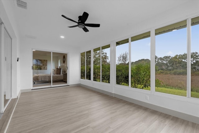 unfurnished sunroom with ceiling fan