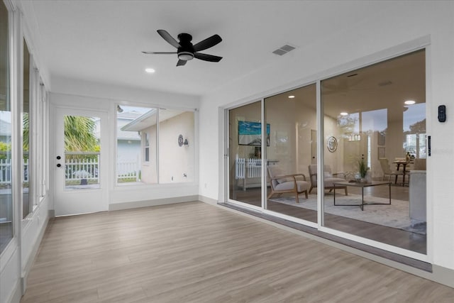 unfurnished sunroom featuring ceiling fan