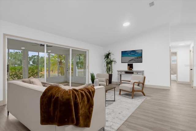 living room with lofted ceiling, light hardwood / wood-style floors, and a healthy amount of sunlight