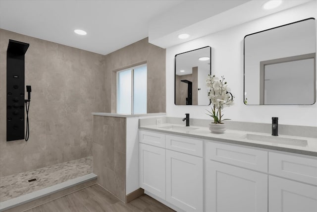 bathroom with vanity, wood-type flooring, and tiled shower