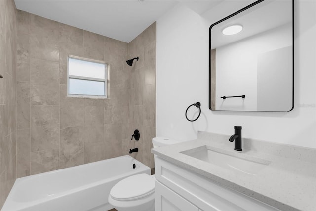 full bathroom featuring tiled shower / bath combo, vanity, and toilet