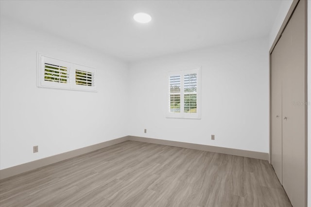 unfurnished bedroom with light hardwood / wood-style floors and a closet