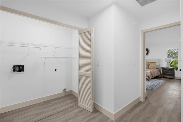 washroom with hookup for an electric dryer, hookup for a washing machine, and light hardwood / wood-style floors