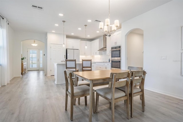 dining space with a chandelier and light wood-type flooring