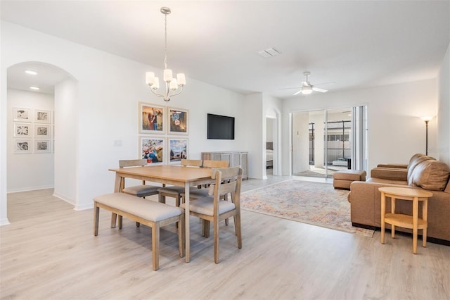 dining area featuring ceiling fan with notable chandelier and light wood-type flooring