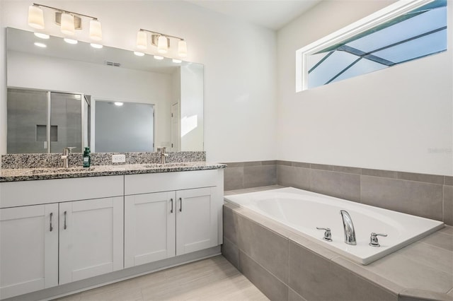 bathroom with vanity and shower with separate bathtub