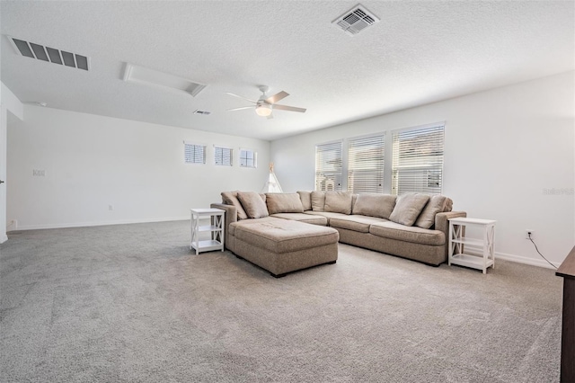 living room with ceiling fan, light colored carpet, and a textured ceiling