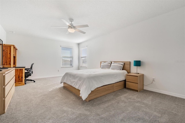 carpeted bedroom with ceiling fan and a textured ceiling