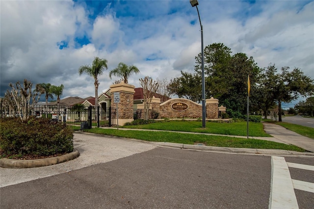 view of property's community with a lawn, fence, and a gate