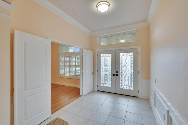 entrance foyer with light tile patterned floors, crown molding, and french doors