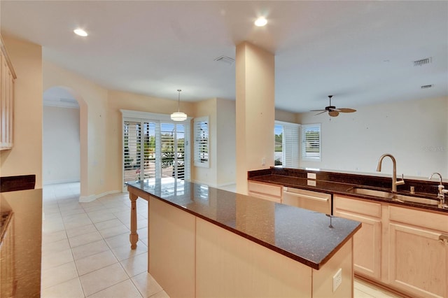 kitchen featuring arched walkways, light tile patterned floors, visible vents, a sink, and dishwasher