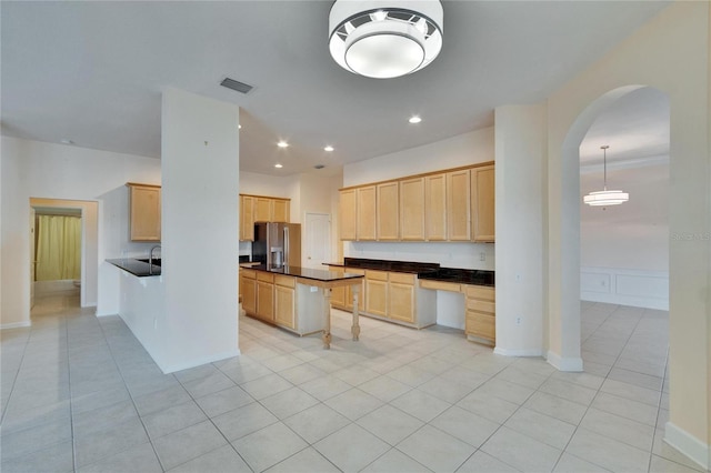 kitchen with visible vents, stainless steel fridge with ice dispenser, dark countertops, light brown cabinets, and light tile patterned flooring