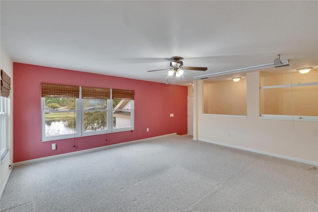 empty room featuring ceiling fan, carpet floors, and baseboards