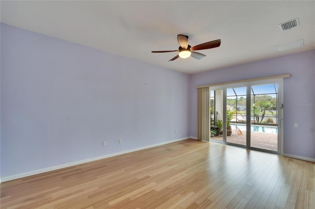 spare room featuring light wood-type flooring, baseboards, visible vents, and ceiling fan