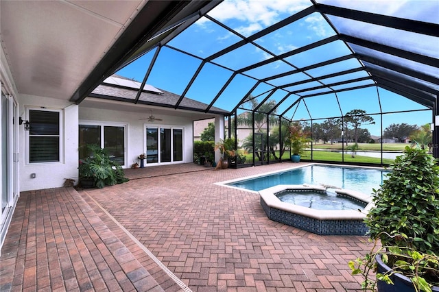 outdoor pool featuring a patio area, glass enclosure, a ceiling fan, and an in ground hot tub