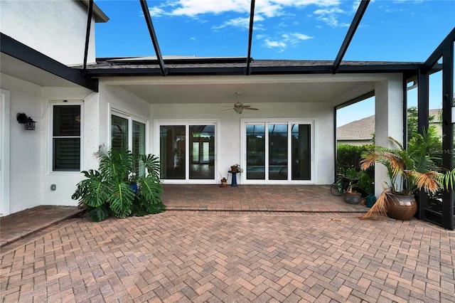 exterior space featuring a lanai, stucco siding, ceiling fan, and a patio