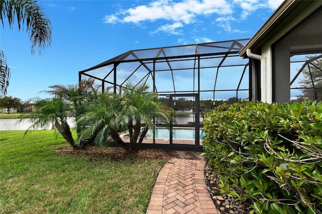 exterior space with a lanai, a water view, and an outdoor pool