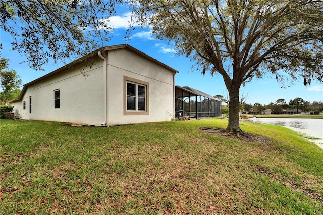 view of property exterior with a lanai, a water view, a lawn, and stucco siding